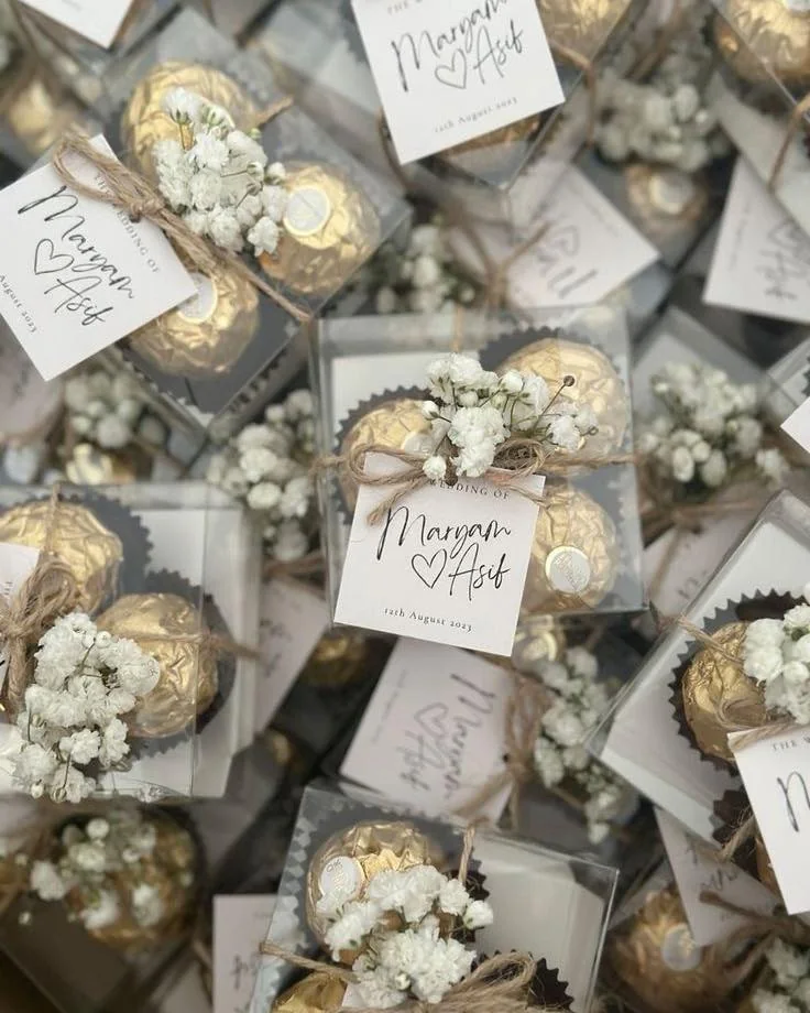 Cadeaux d'invités dorés avec gypsophile et étiquettes